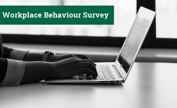 Hands on a keyboard with text 'workplace behaviour survey'